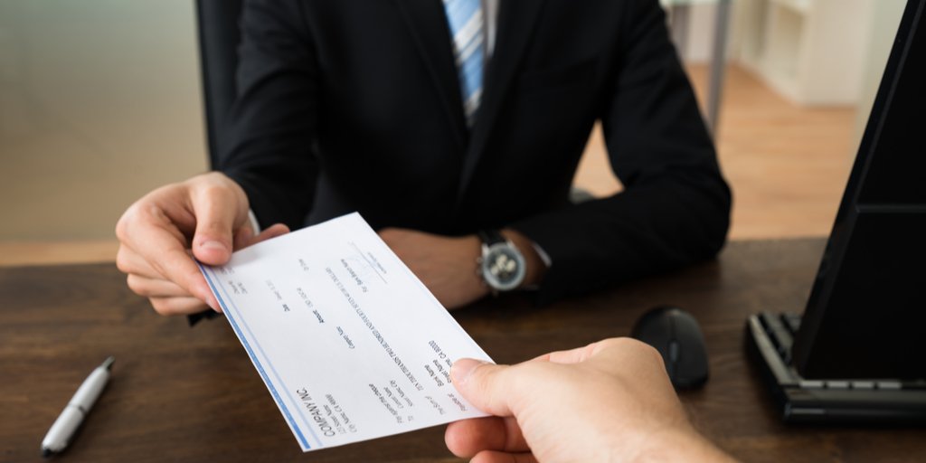 employer handing candiate salary pay check